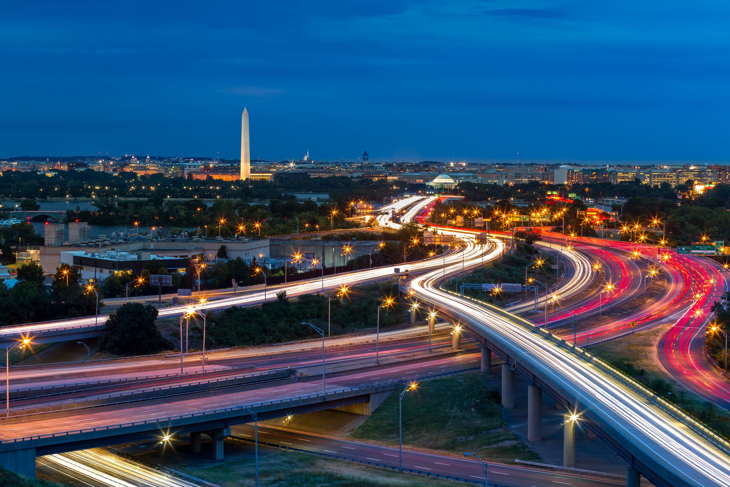Washington, DC highways at night with the Washington Monument and Capitol